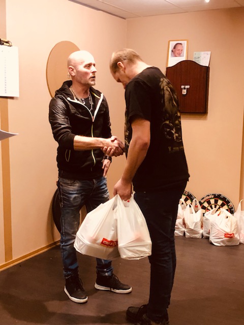 En artigt bugande Johan Lööf tar emot prispåse till sig själv och parhästen Stickan.